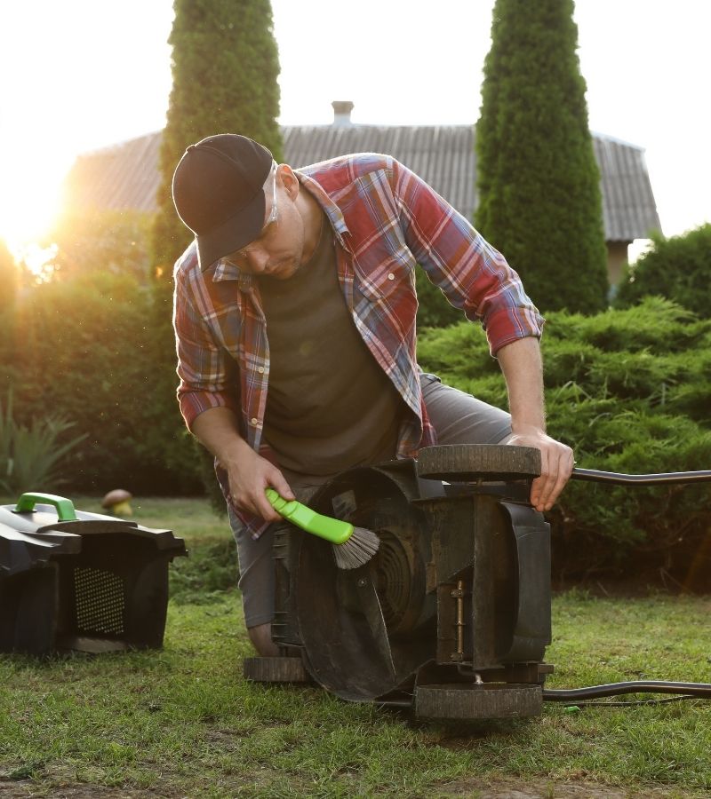 Man cleaning lawn mower