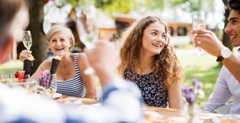 Friends and family enjoying a summer garden gathering outdoors in a tidy and well-maintained garden.