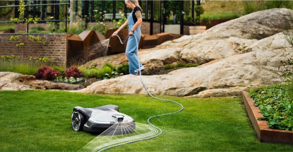 Robotic lawn mower operating on a lawn in a modern garden, demonstrating the convenience of automated battery-powered mowing.