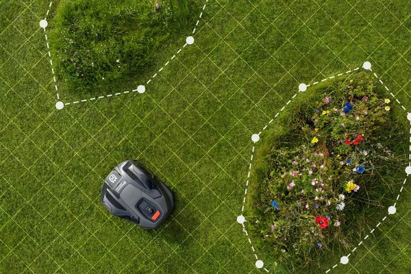 Robotic lawn mower navigating around flower beds using virtual mowing boundaries.