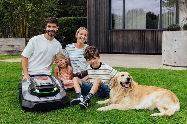 Family with a robotic lawn mower in a garden, suitable for typical family-sized lawns.