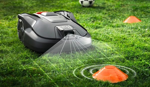 Robotic lawn mower detecting an obstacle while automatically mowing a garden lawn.